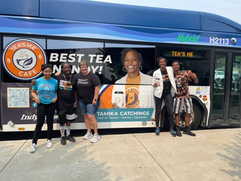 Catchings and some of her Tea's Me Cafe team in front of their new ad